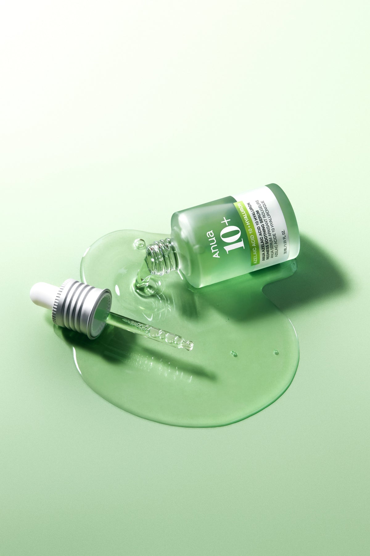 Anua Azelaic Acid 10% Soothing Serum 30ml - green bottle lying on a green gel swatch