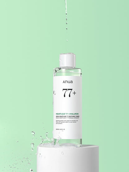 Anua Heartleaf 77% Soothing Toner 250ml - clear toner bottle dripping over a green background