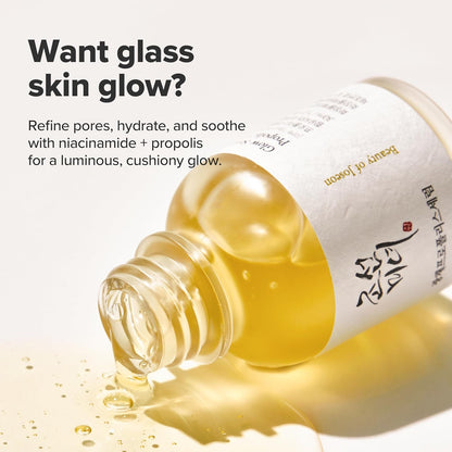 Want glass skin glow: the bottle lying in spilled serum, refining pores and soothing with niacinamide and propolis for a luminous cushiony glow