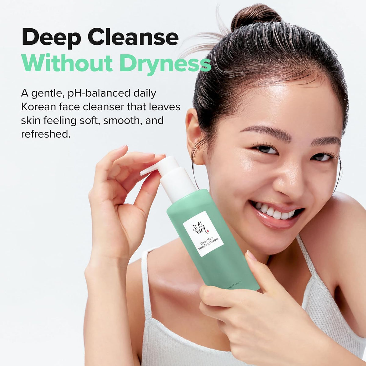 A smiling model holding the cleanser: deep cleanse without dryness, a gentle pH-balanced daily cleanser