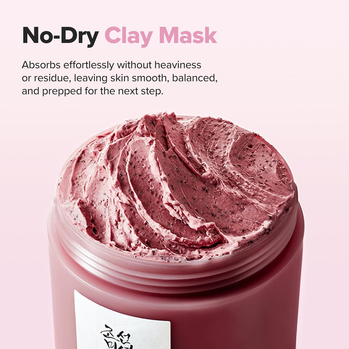No-dry clay mask: a close-up of the speckled pink clay inside the open jar, absorbs without heaviness or residue