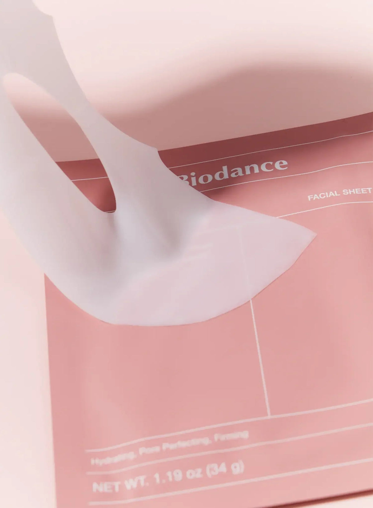 Biodance Bio-Collagen Deep Mask 4 Pack - the collagen gel mask sheet being lifted from the pack, on a pink background