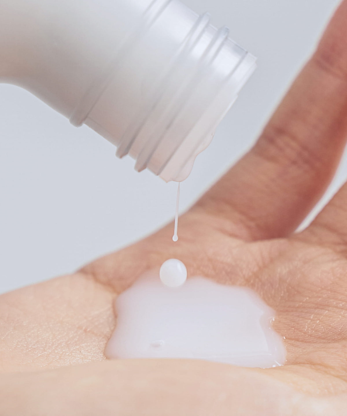 Celimax Dual Barrier Creamy Toner 150ml - a bottle pouring the creamy toner into a cupped hand