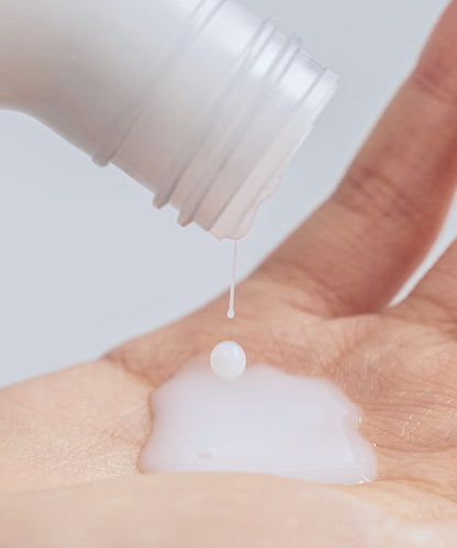 Celimax Dual Barrier Creamy Toner 150ml - a bottle pouring the creamy toner into a cupped hand