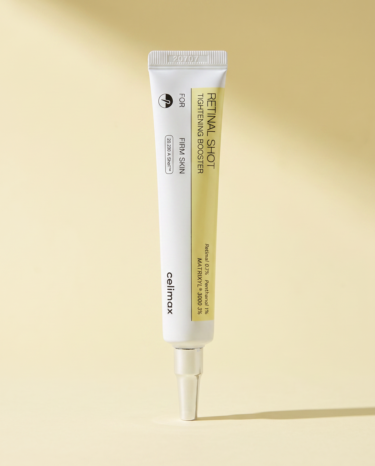 Celimax Retinal Shot Tightening Booster 15ml - slim white tube lying on a pale yellow background