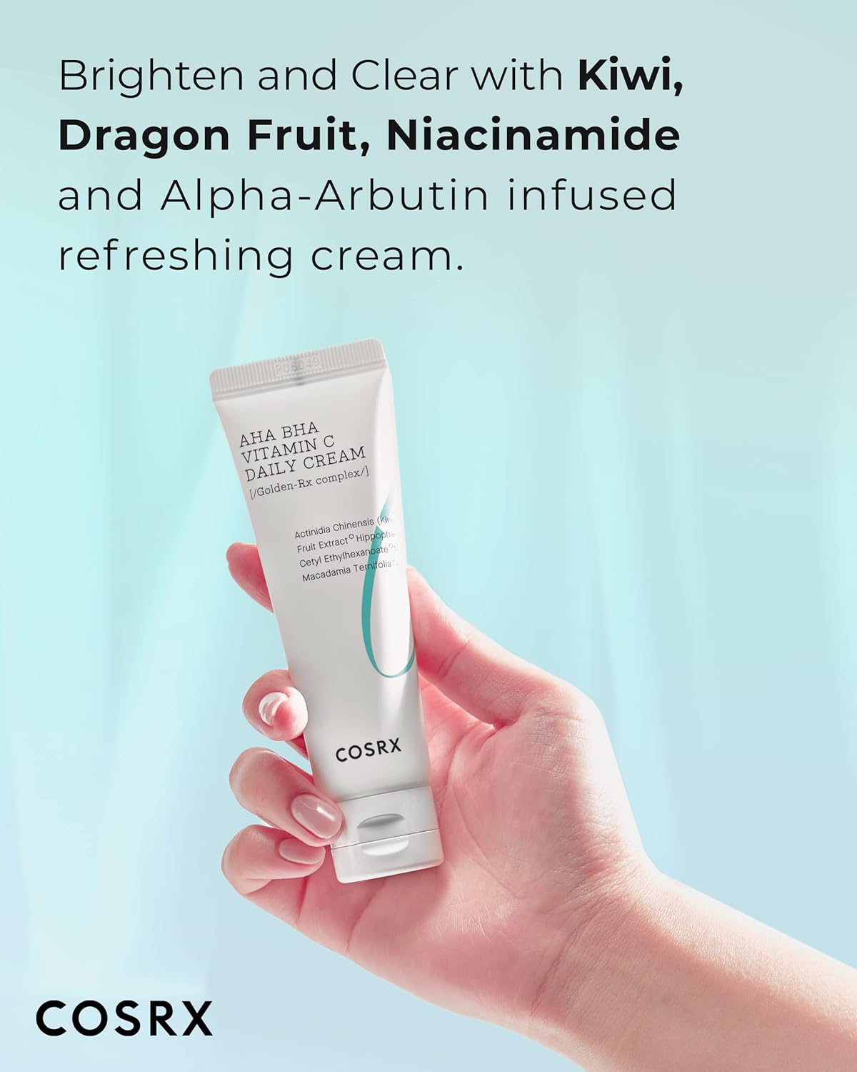 A hand holding the AHA BHA Vitamin C Daily Cream tube: brighten and clear with kiwi, dragon fruit, niacinamide and alpha-arbutin