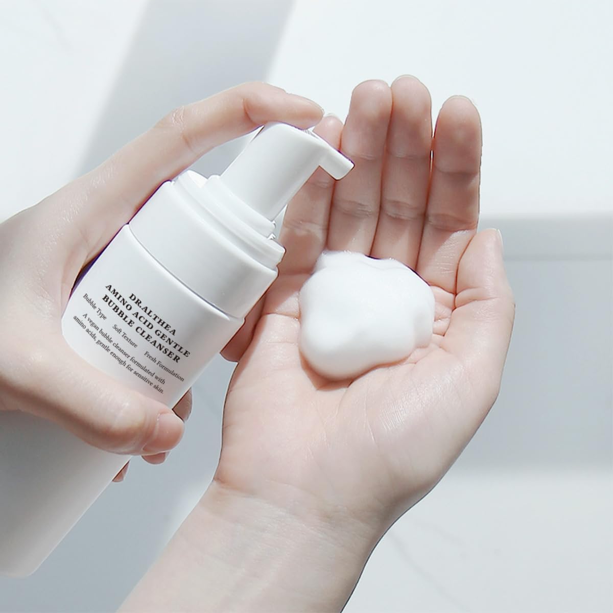 Hands pumping a puff of foam from the bottle