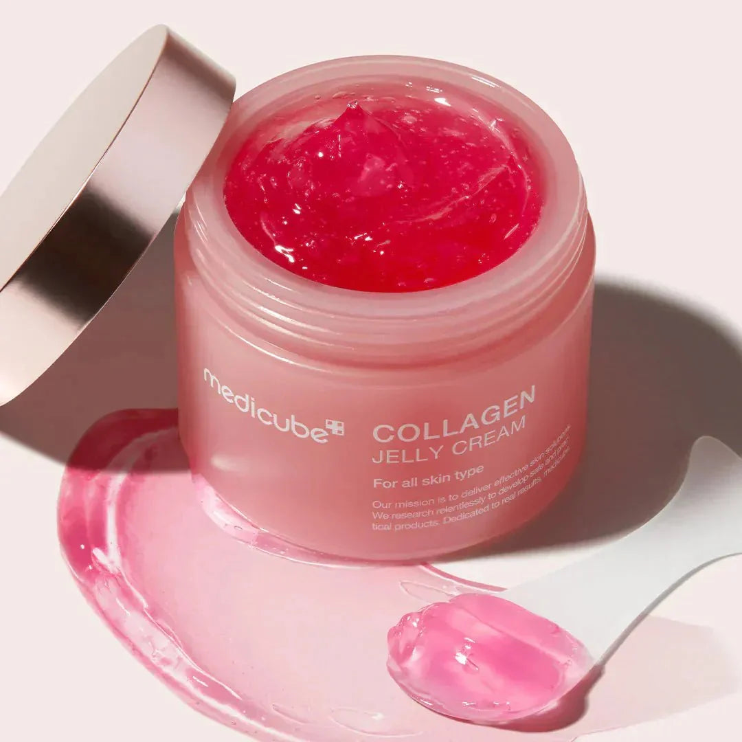 Open jar tilted to show the deep pink jelly, with a spatula holding a scoop of the product