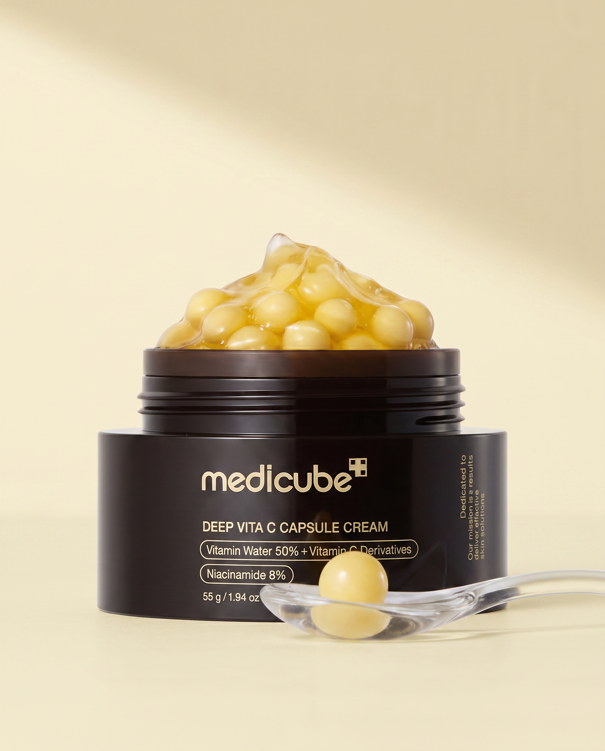 Medicube Deep Vita C Capsule Cream 55g - open black and gold jar of yellow capsules with a spatula