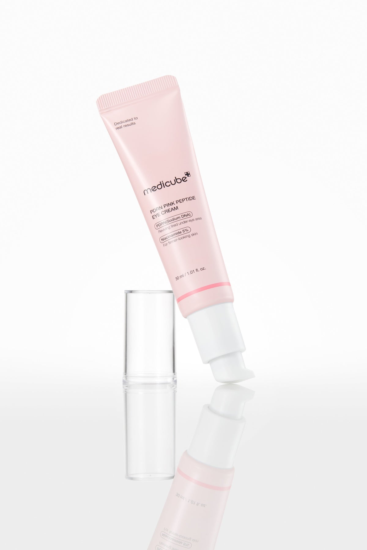 Medicube PDRN Pink Peptide Eye Cream 30ml - pink tube lying beside its clear cap, white background