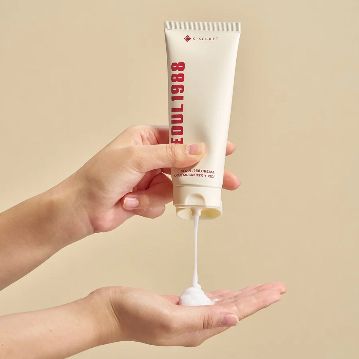 Seoul 1988 Snail Mucin Cream 100ml - hands dispensing the cream from the tube onto a palm