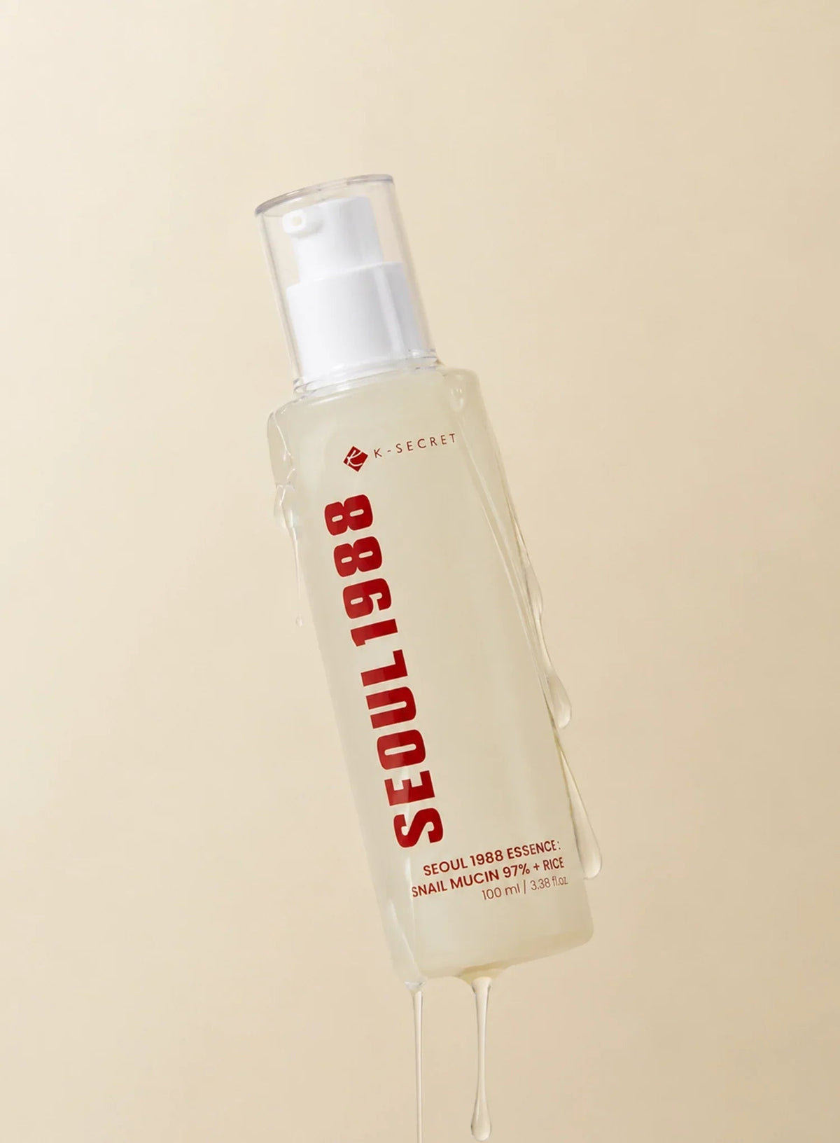 Seoul 1988 Snail Mucin Essence 100ml - pump bottle with a drip of the essence from the nozzle