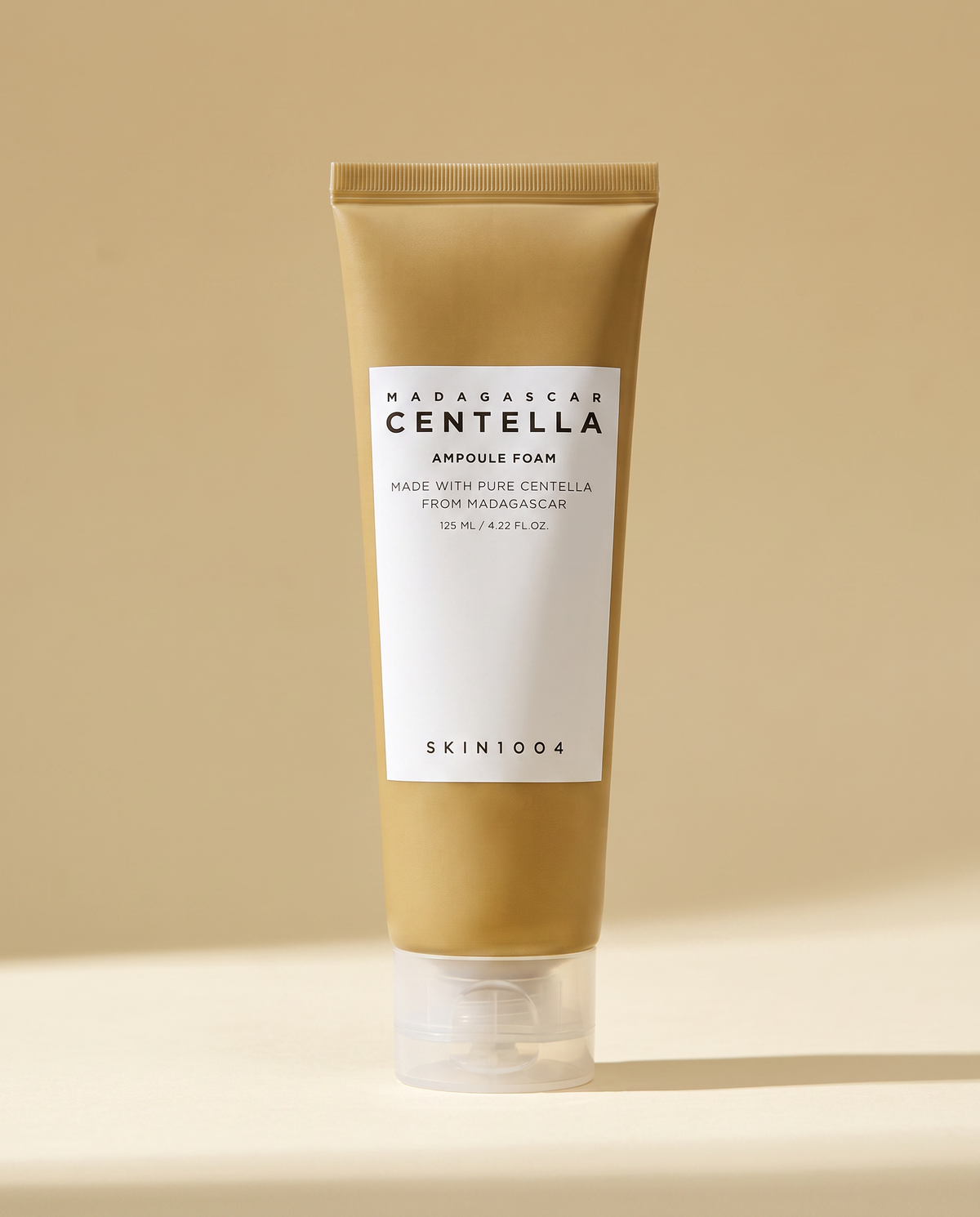 SKIN1004 Centella Ampoule Foam 125ml - tan ampoule foam tube on a warm gold background