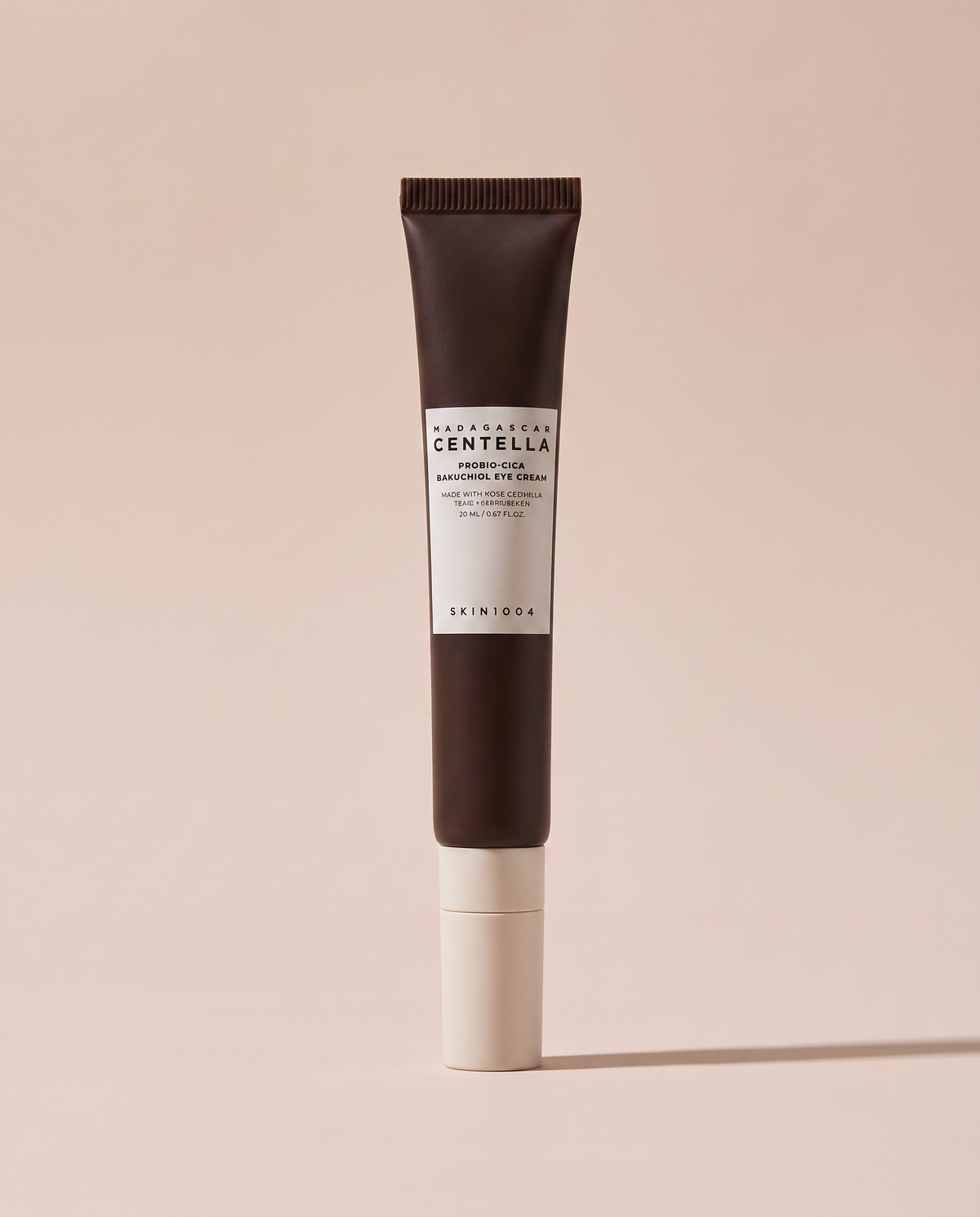 SKIN1004 Centella Bakuchiol Eye Cream 20ml - dark-capped tube on a dusty pink background