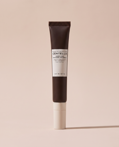 SKIN1004 Centella Bakuchiol Eye Cream 20ml - dark-capped tube on a dusty pink background