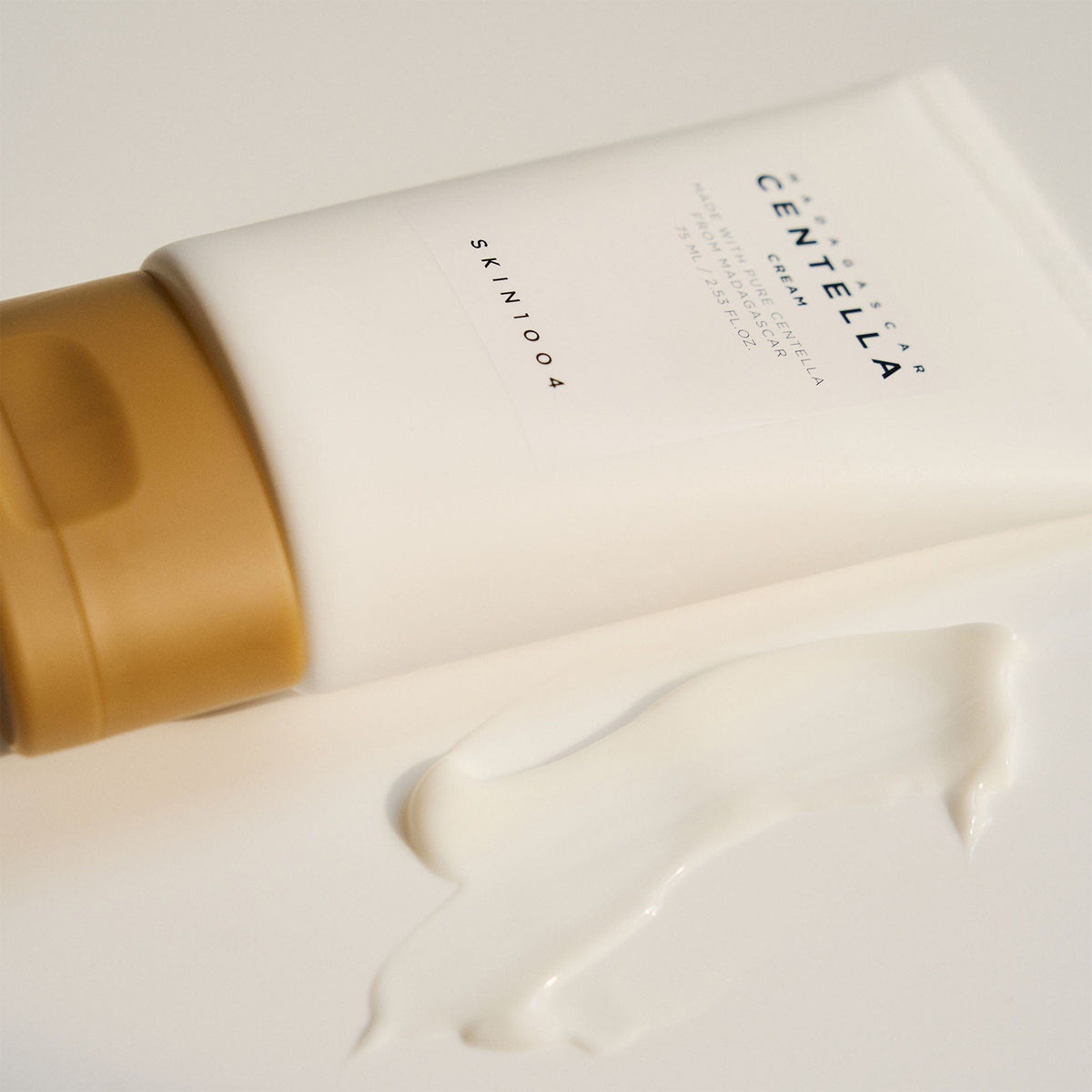 SKIN1004 Madagascar Centella Cream 75ml tube beside a smooth swipe of rich white cream
