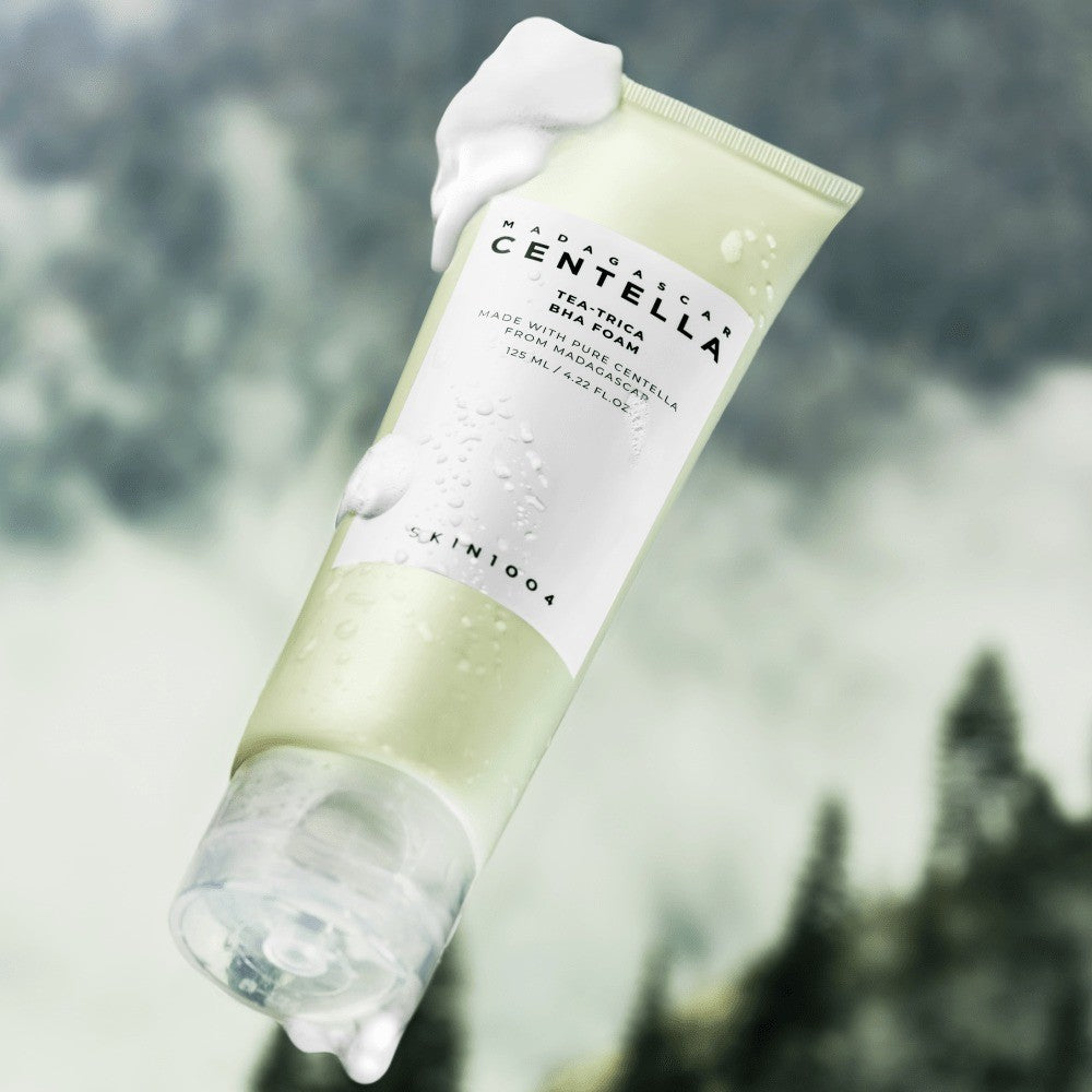 SKIN1004 Madagascar Centella Tea-Trica BHA Foam 125ml tube topped with foam against a misty pine forest
