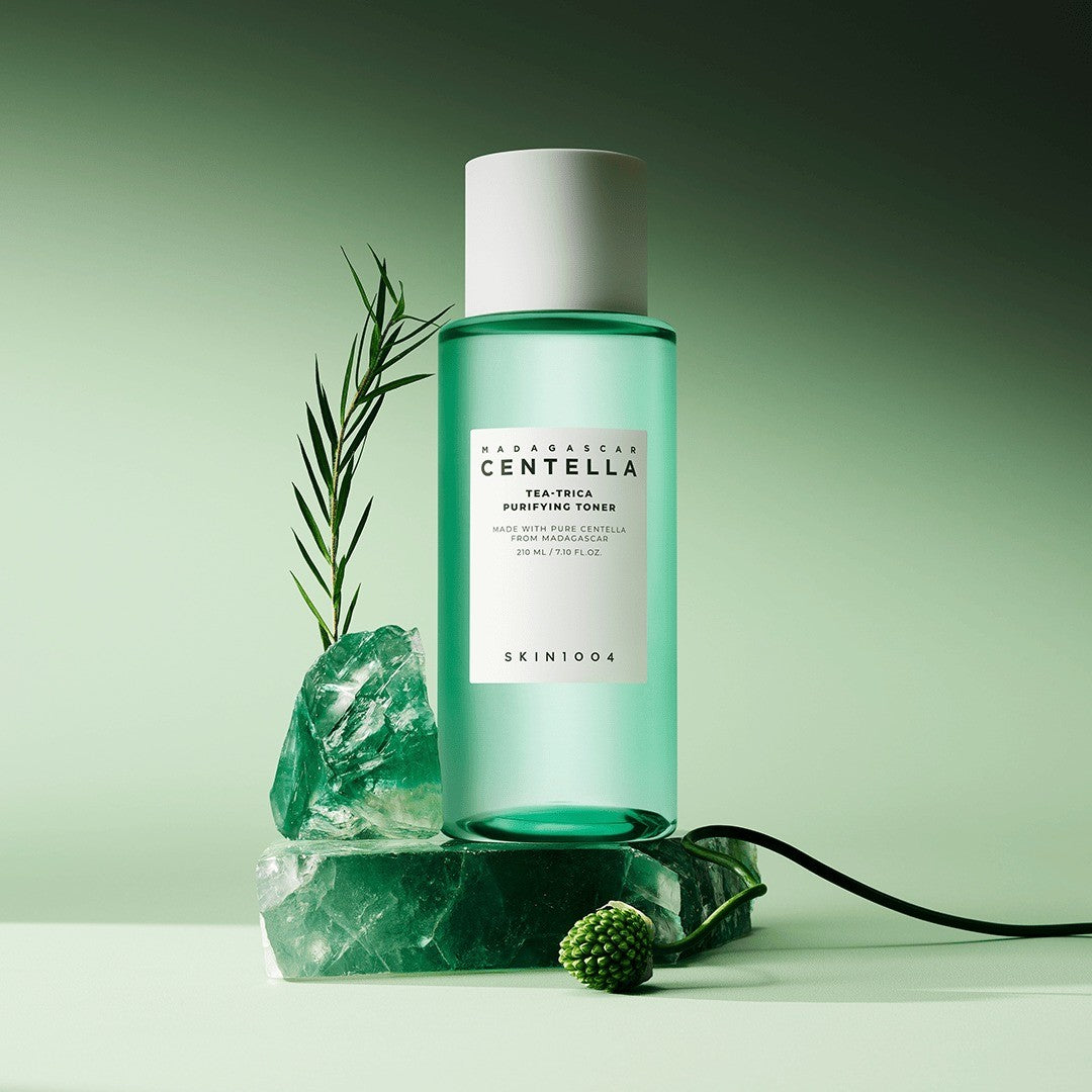 SKIN1004 Madagascar Centella Tea-Trica Purifying Toner 210ml lifestyle shot of the green bottle on a crystal stone with a tea tree sprig
