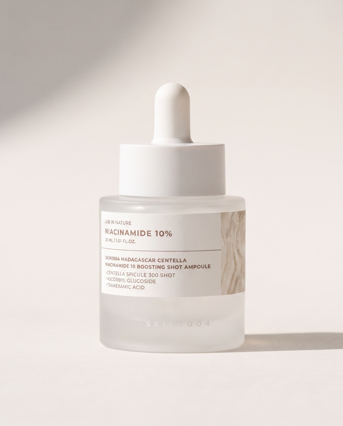 SKIN1004 Niacinamide 10% Boosting Ampoule 30ml - cream dropper bottle on a pale beige background